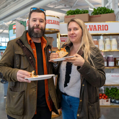 SAP_PizzaFestChallenge2025_Jour1_Finales-136 (1) A man and woman attending the Gold Pizza Competition and eating pizza